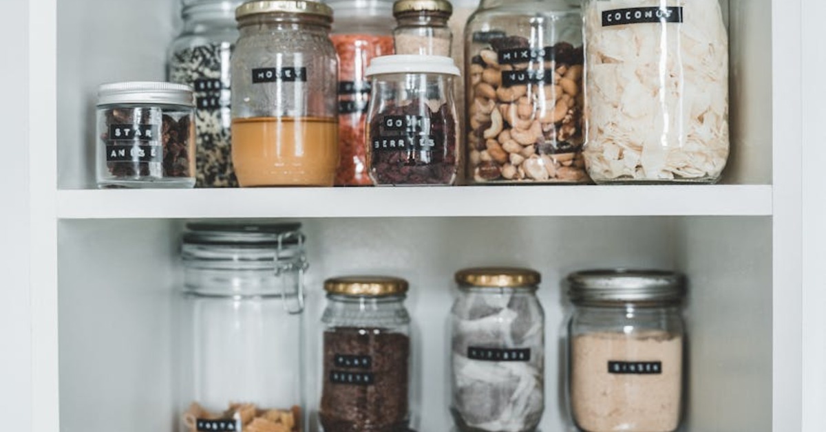 Usporiadaná špajza s priehľadnými dózami a označenými policami